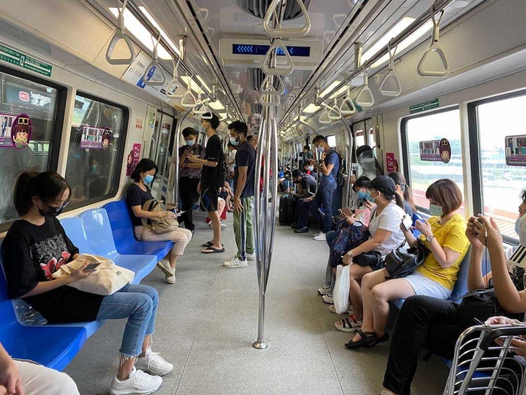 Penumpang tren MRT di Singapura mengekalkan penjarakan fizikal dan memakai pelitup muka bagi membendung Covid-19. Gambar: AP