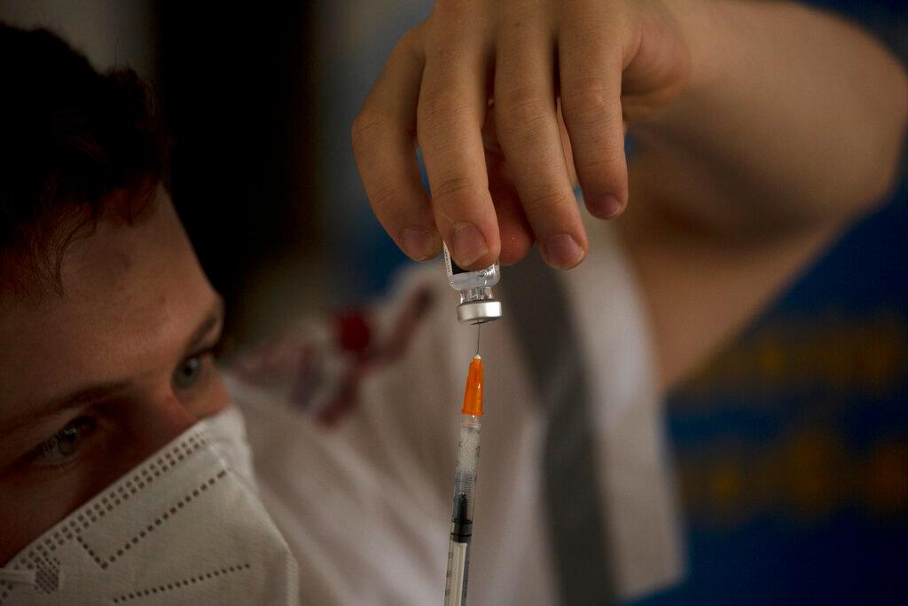 An Israeli medic prepares a syringe of the coronavirus vaccine at a senior centre in Jerusalem, Aug 4. Israel has begun administering coronavirus booster shots to people over 60 who've already received both does of a vaccine, in a bid to combat a recent spike in cases. Photo: AP
