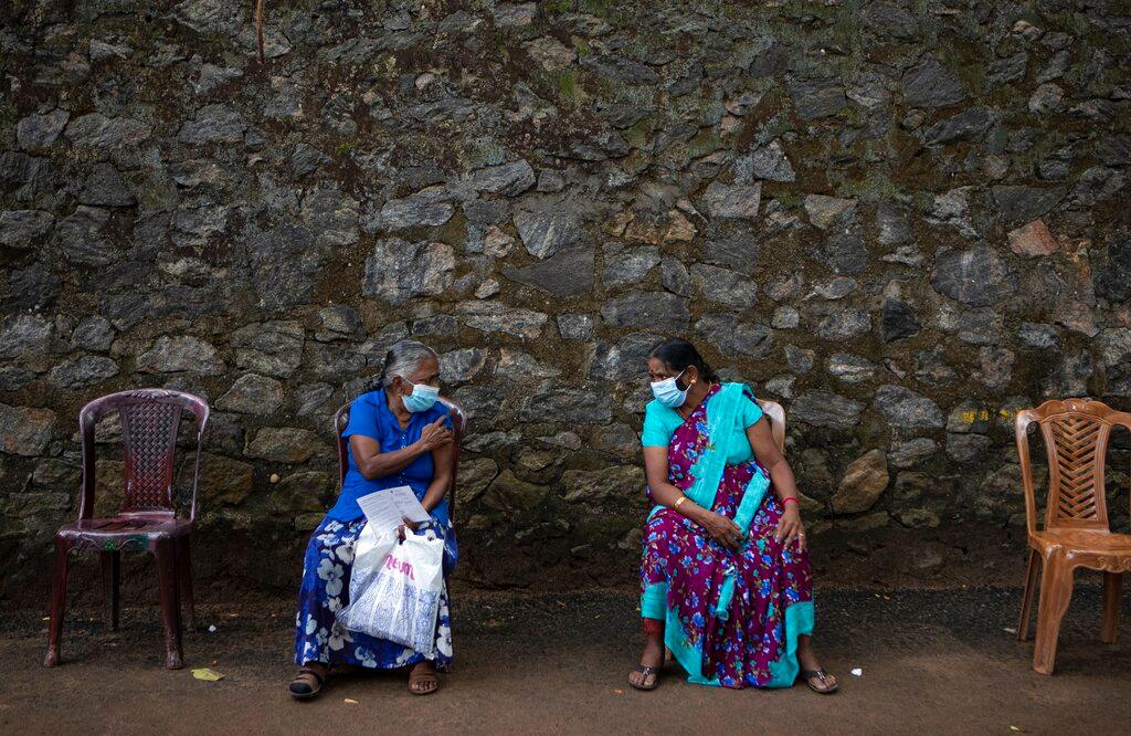 Elderly Sri Lankan women chat after getting inoculated against the coronavirus in Colombo, Sri Lanka, Aug 10. The Indian Ocean island nation is facing its most severe spike of the pandemic, driven by the highly contagious Delta variant. Photo: AP