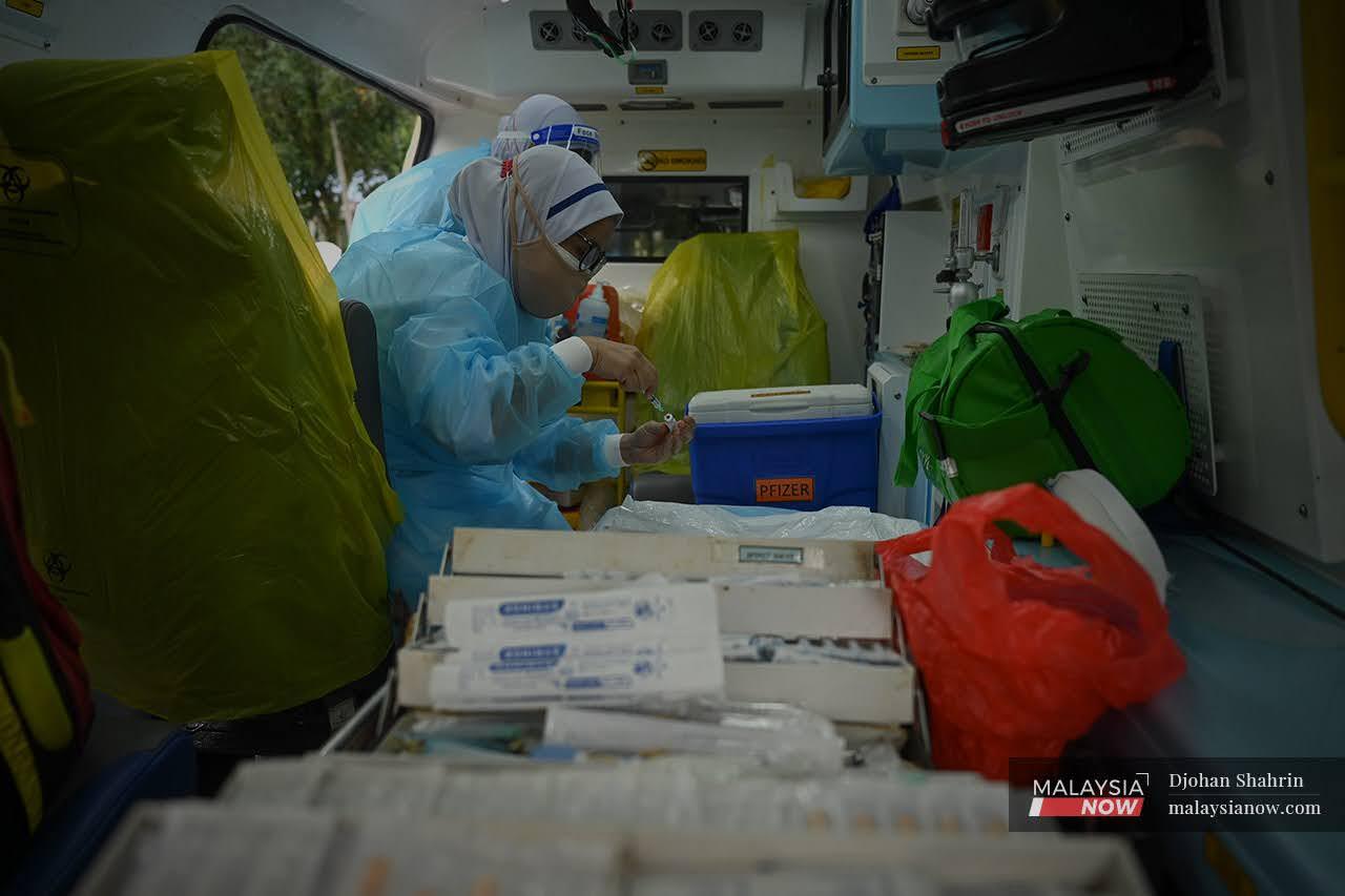 Petugas Kesihatan Hospital Orang Asli Gombak melakukan persediaan vaksin ke dalam picagari ketika program vaksinasi Orang Asli di sekitar daerah Hulu Langat di Sungai Gabai.