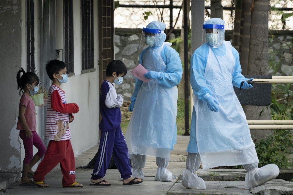 Health workers guide children to a screening site for Covid-19 in this file photo. Sabah says more than 600 cases recorded yesterday involved children aged six to 17. Photo: AP