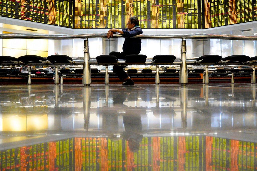 Seorang lelaki duduk di hadapan papan dagangan saham di Kuala Lumpur dalam gambar fail bertarikh 13 Disember 2018. Gambar: AP