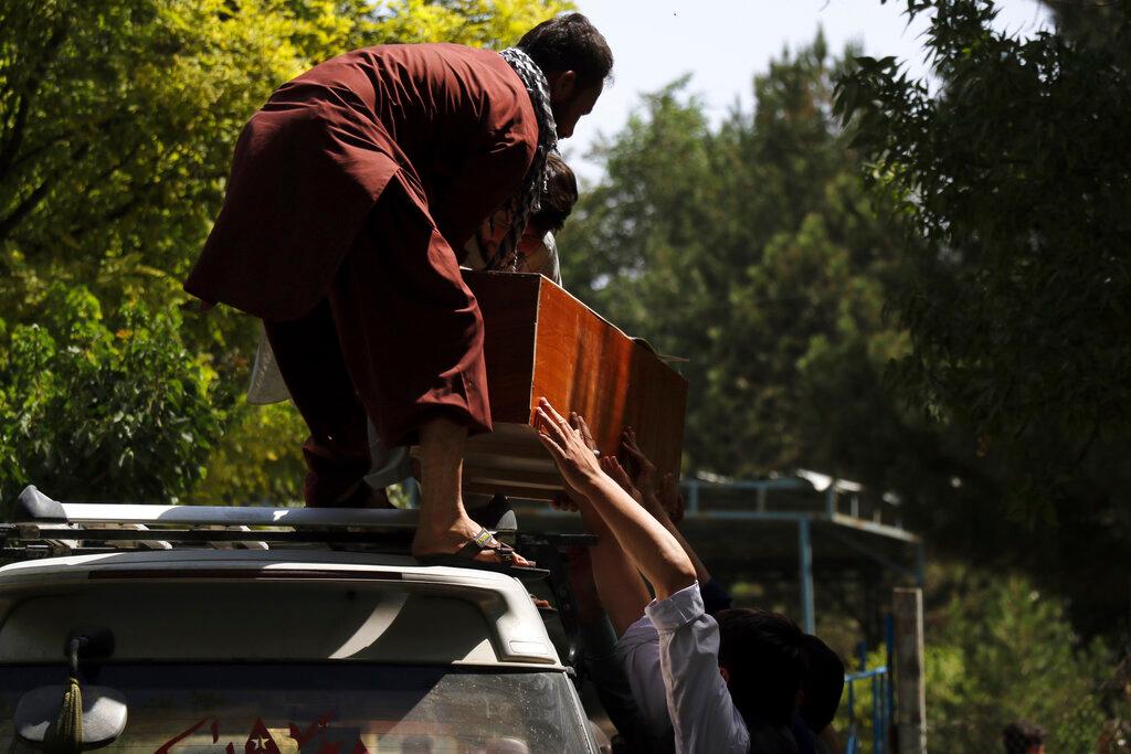 Afghans carry a body in a coffin at a hospital in Kabul, Afghanistan, Aug 27, a day after deadly attacks outside the airport. Photo: AP