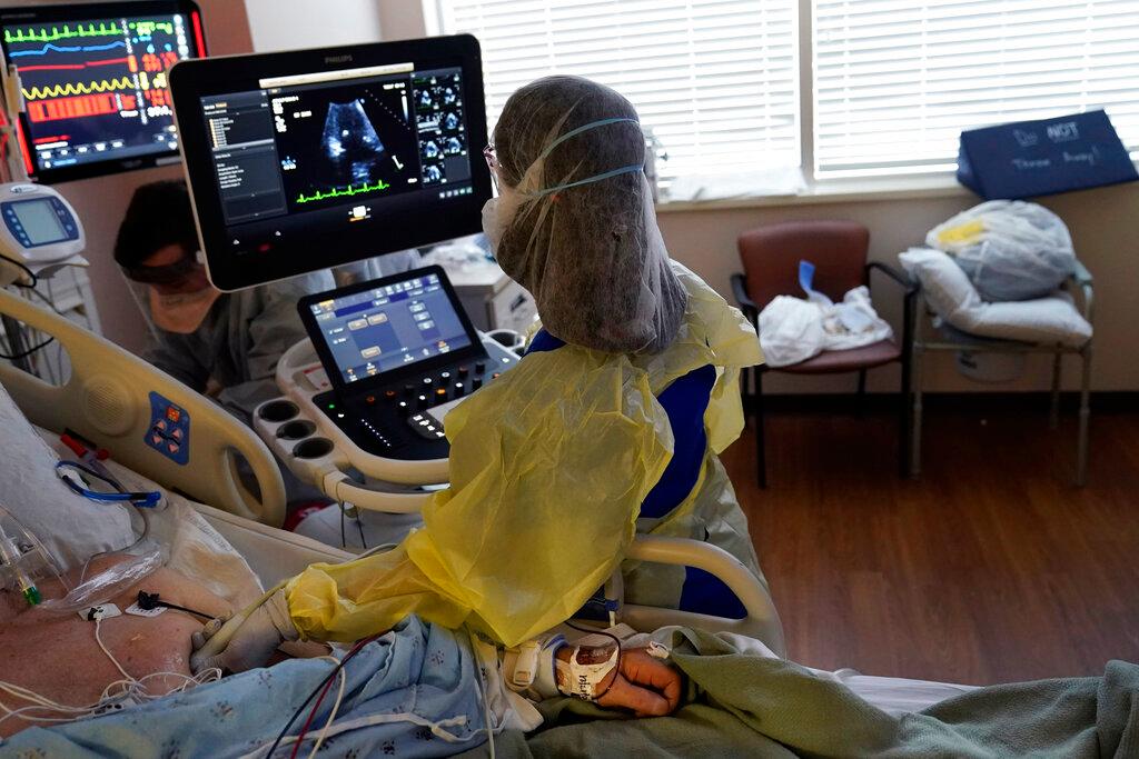 A technician takes readings from a critically ill Covid-19 patient, in an ICU in Louisiana, Aug 17. Photo: AP