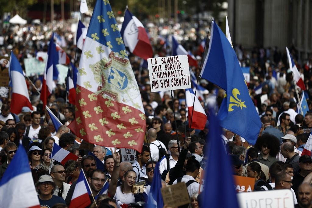 Protesters holding French flags and the fleur-de-lys royalist symbol take part in a rally against the compulsory Covid-19 vaccination for certain workers and the mandatory use of the health pass, in Paris on Aug 28. Photo: AFP