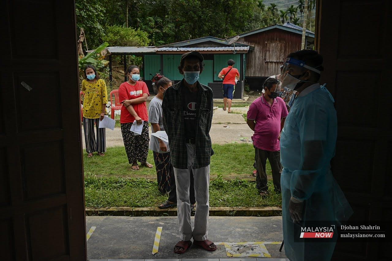 Orang Asli from the Temuan tribe queue to receive their vaccine jabs at a hall in Sungai Congkak, Hulu Langat in Selangor.