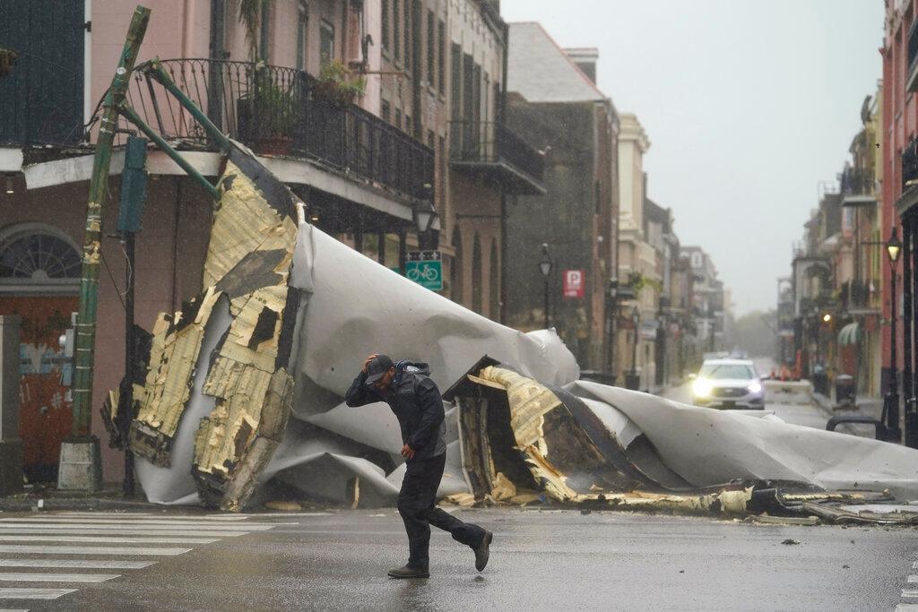 A man passes by a section of roof that was blown off of a building in the French Quarter by Hurricane Ida winds, Aug 29, in New Orleans. Photo: AP