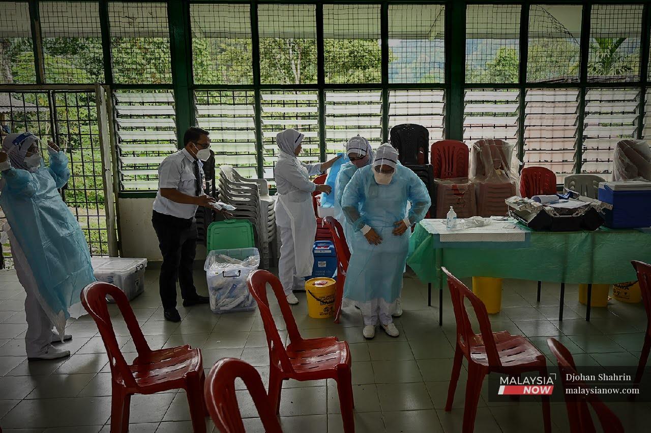 Health workers prepare to administer vaccine shots to the Orang Asli community in Hulu Langat, Selangor.