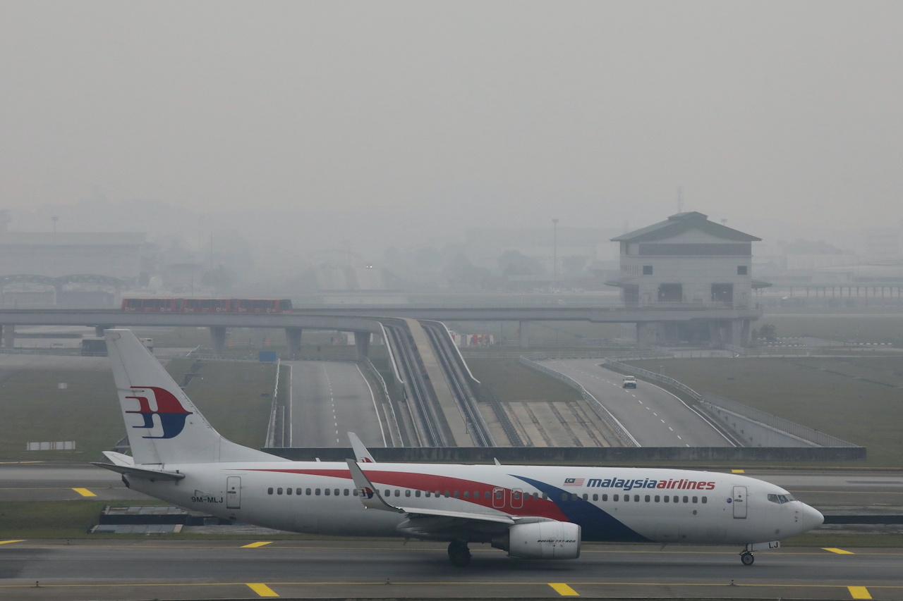 FILE PHOTO: A Malaysia Airlines Boeing 737 airplane is pictured on the haze-shrouded tarmac at Kuala Lumpur International Airport in Sepang