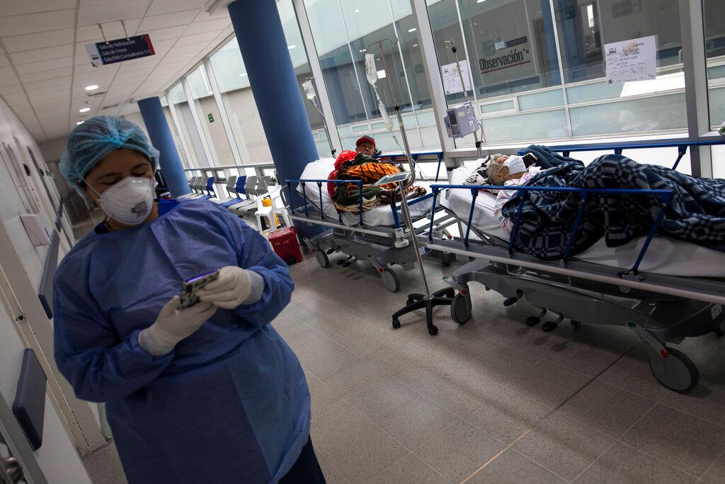 A nurse checks her phone next to patients suffering from Covid-19 at the Regional Hospital in Zipaquira, Colombia, on June 28 during the country's third wave of infections which also saw a surge in deaths. Photo: AP