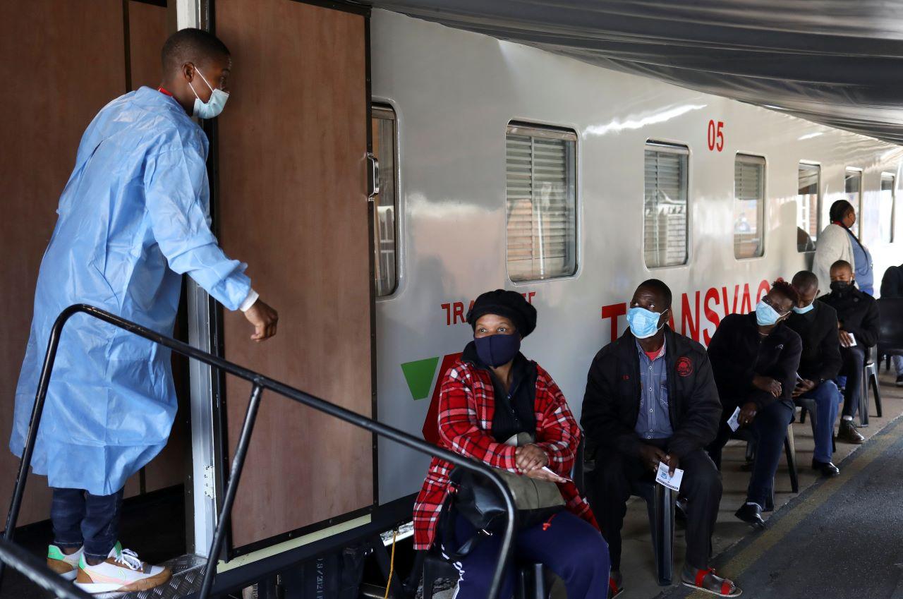 A health worker talks to people as they wait to register next to the Transvaco coronavirus disease vaccine train, after South Africa's rail company Transnet turned the train into a Covid-19 vaccination centre on rails to help the government speed up its vaccine rollout in the country's remote communities, Aug 30. Photo: Reuters