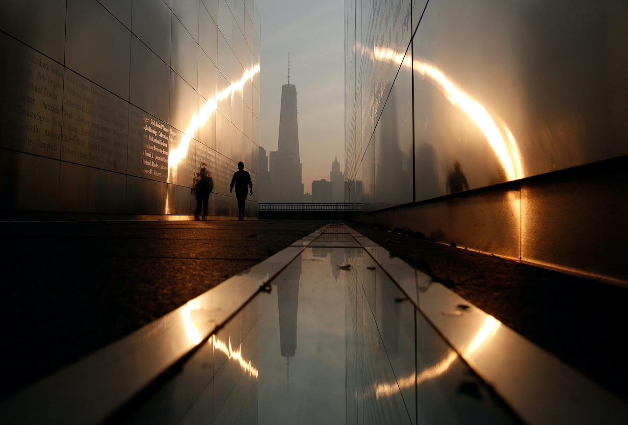 A man walks through the 9/11 Empty Sky memorial at sunrise across from New York's Lower Manhattan and One World Trade Center in Liberty State Park in Jersey City, New Jersey, Sept 11, 2013. Photo: Reuters