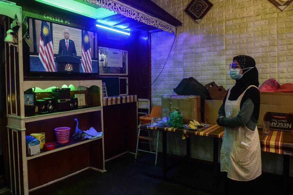 A worker watches as Ismail Sabri Yaakob gives his inaugural speech as prime minister on Aug 22, during which he introduced the 'Malaysian Family' tag line. Photo: Bernama