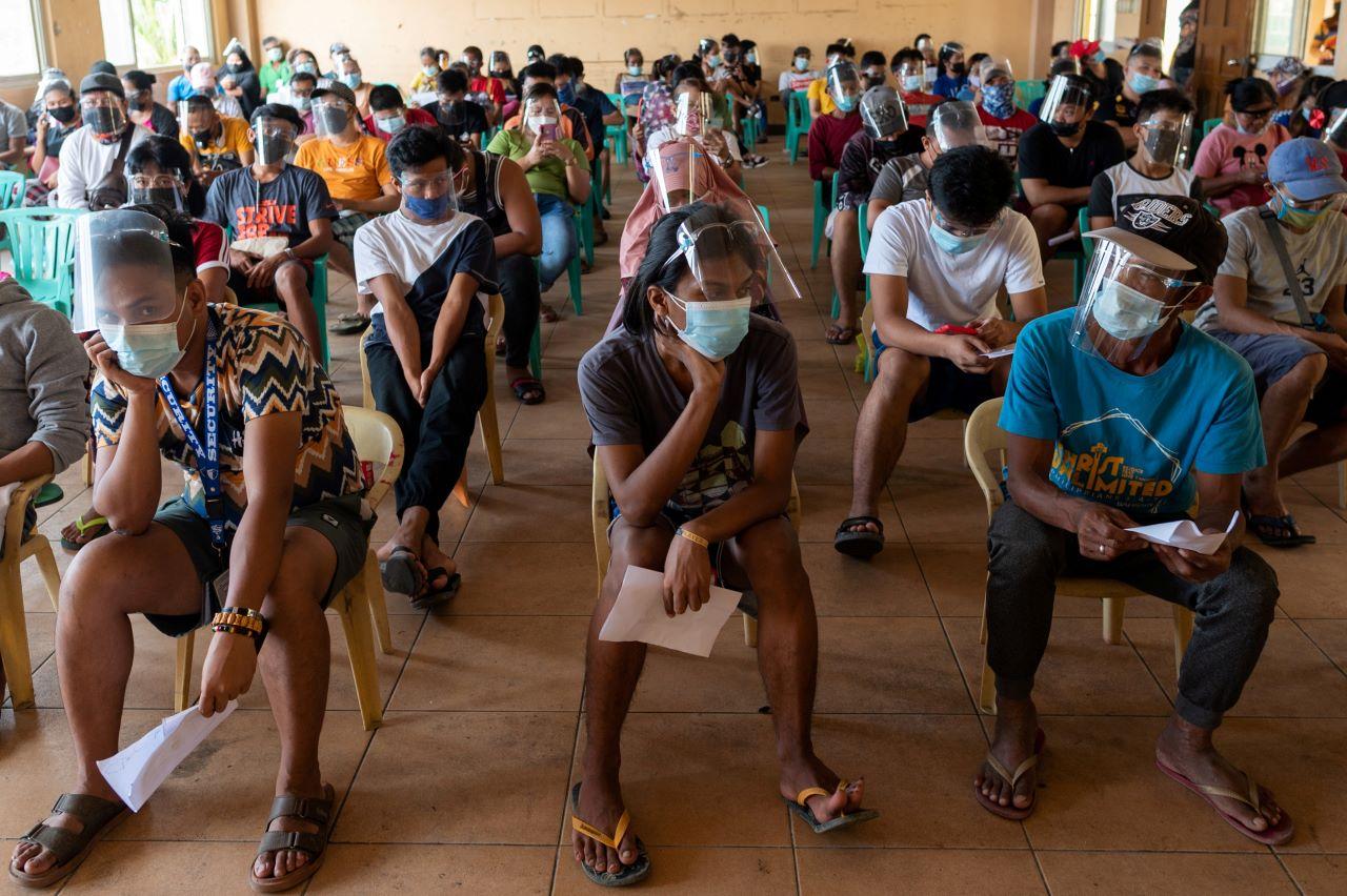 Residents queue to receive cash assistance from the government following the imposition of a lockdown to prevent the spread of the Delta variant, at an evacuation centre, in Manila, Philippines, Aug 11. The stay-at-home order in the capital Manila will be lifted this week. Photo: Reuters