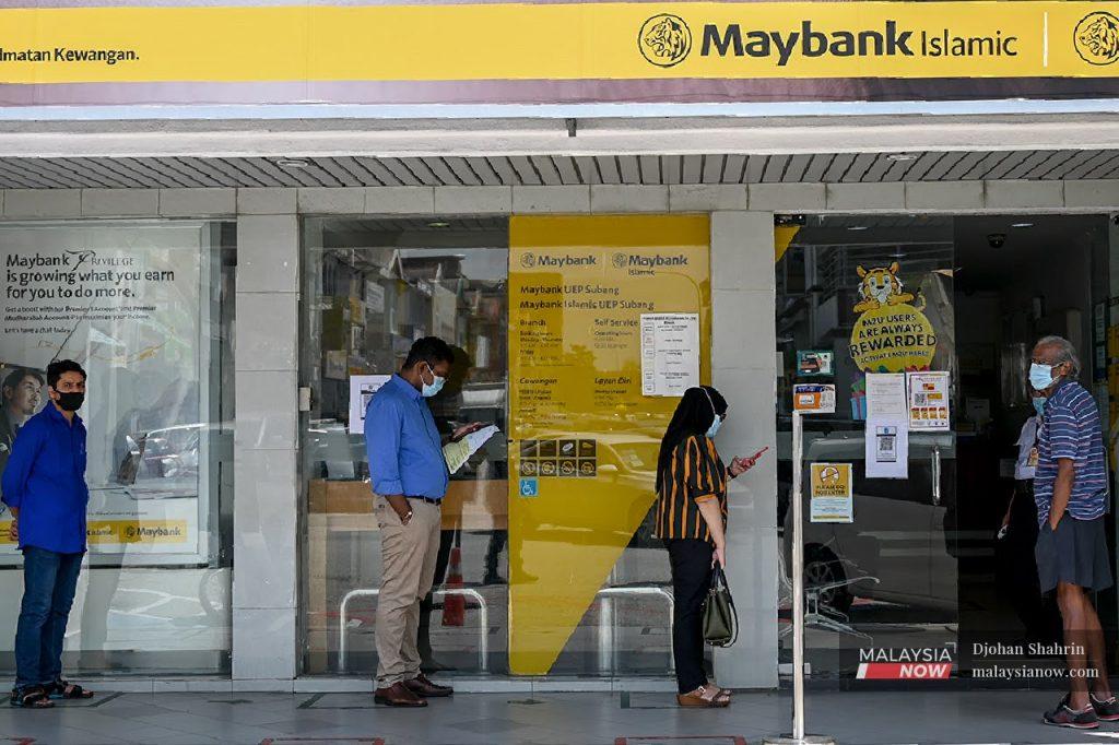 People observe SOPs while queuing outside a Maybank Islamic branch in USJ. Several loan moratoriums have been implemented by the government since the onset of the Covid-19 crisis in the country.