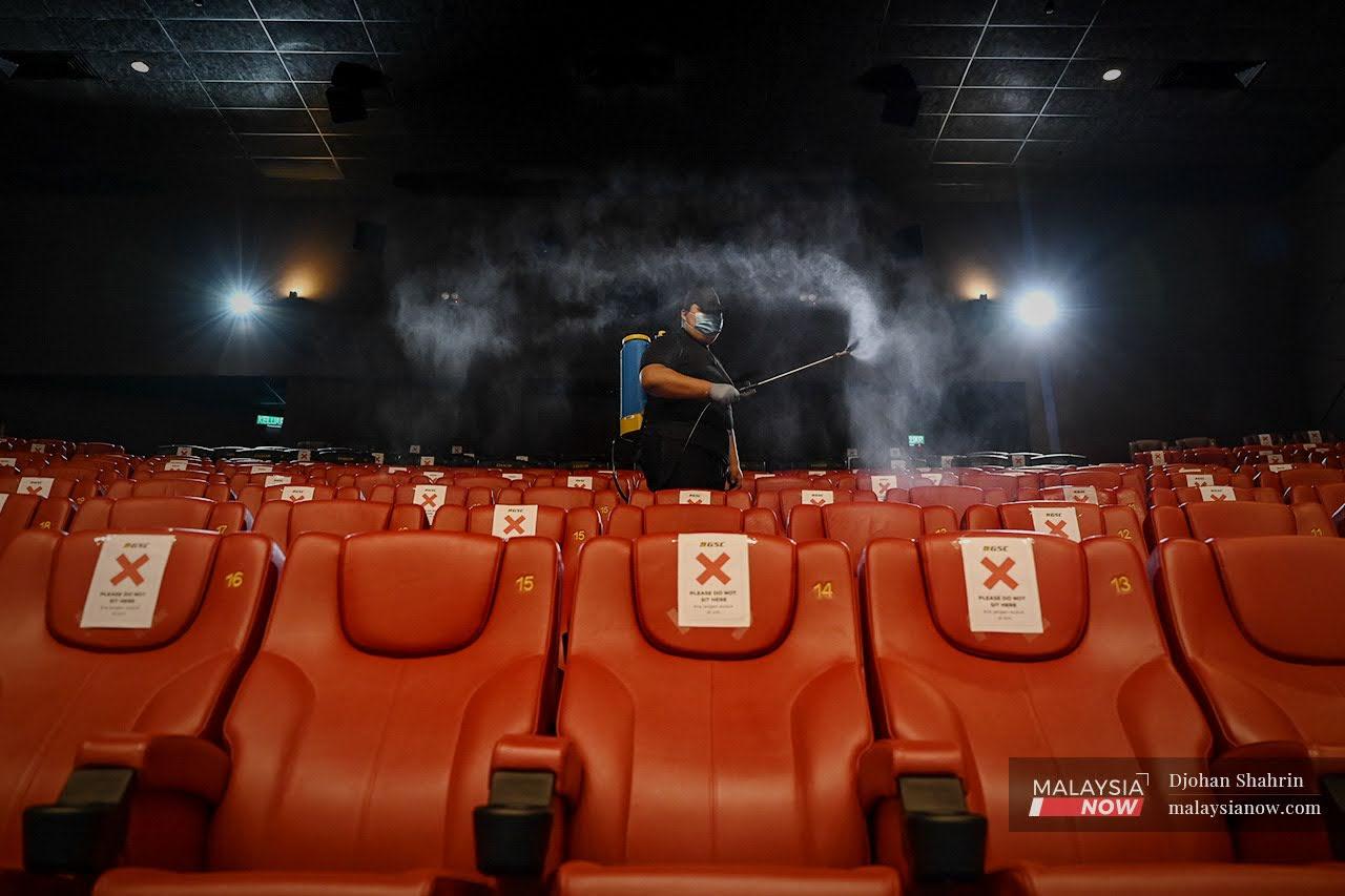 Seorang pekerja pawagam melakukan semburan cecair pembasmi kuman dalam dewan pawagam di Golden Screen Cinema (GSC) Mid Valley.