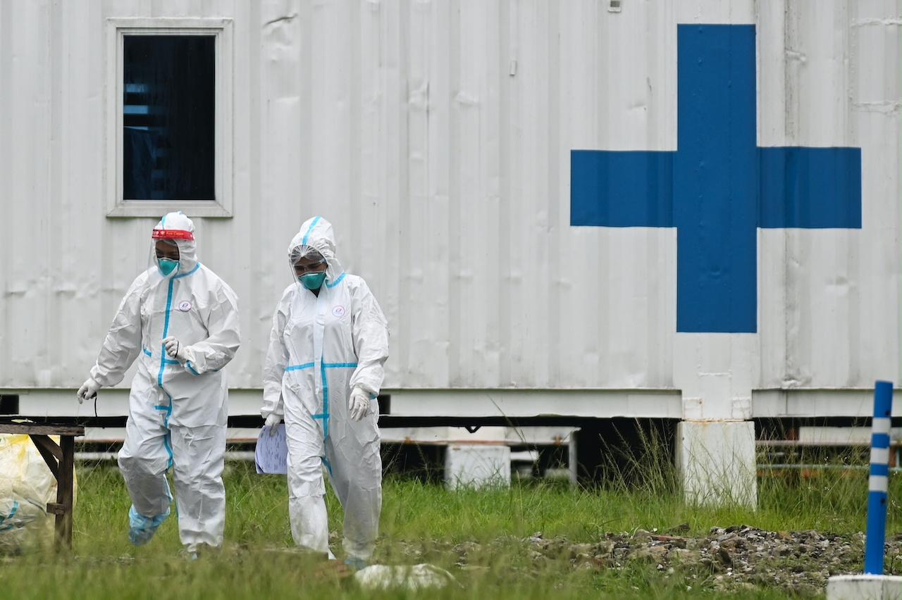 Health workers in hazmat suits walk outside the Manila Covid-19 Field Hospital in Manila, Philippines, Sept 7. Photo: Reuters