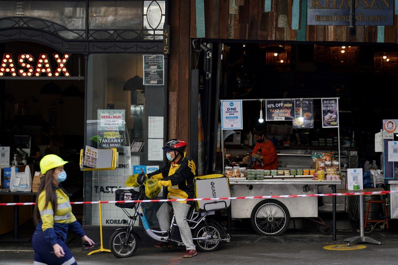 A construction worker, delivery courier and restaurant staff wear protective face masks while working in the city centre during a lockdown to curb the spread of a Covid-19 outbreak in Sydney, Australia, Sept 9. Photo: Reuters