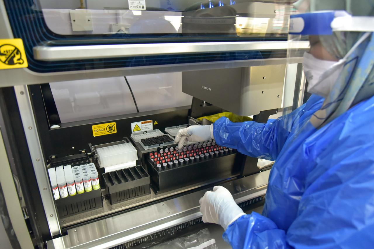 A medical officer works at the extraction room of the Covid-19 PCR test laboratory in Labuan Nucleus Hospital. Photo: Bernama