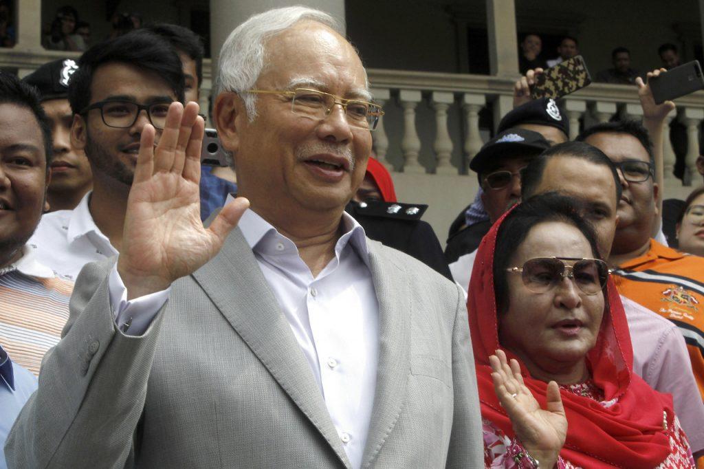 Former prime minister Najib Razak and his wife Rosmah Mansor wave to their supporters as they exit the Kuala Lumpur High Court in July 2018. Photo: AP