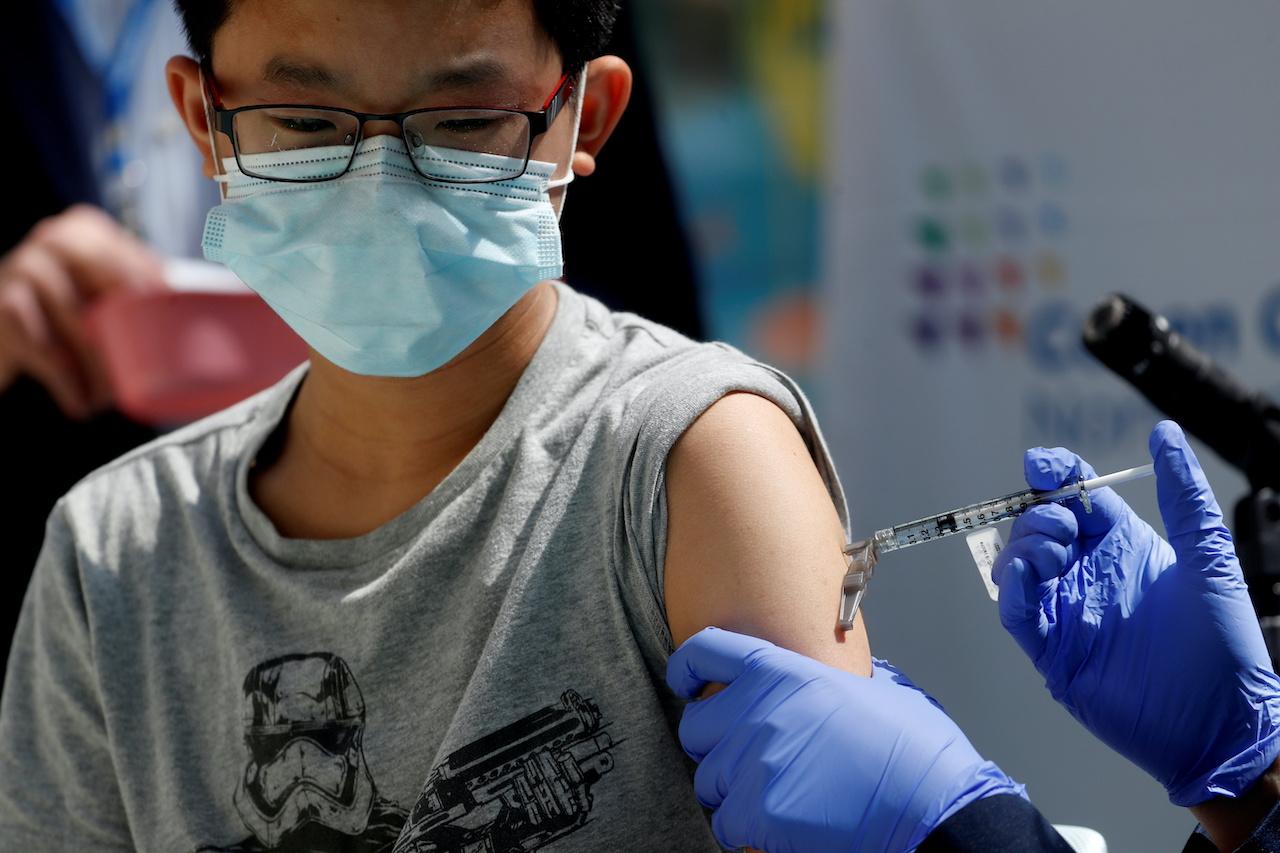 A teenager receives a dose of Pfizer vaccine at a centre in New Hyde Park, New York, May 13. Photo: Reuters