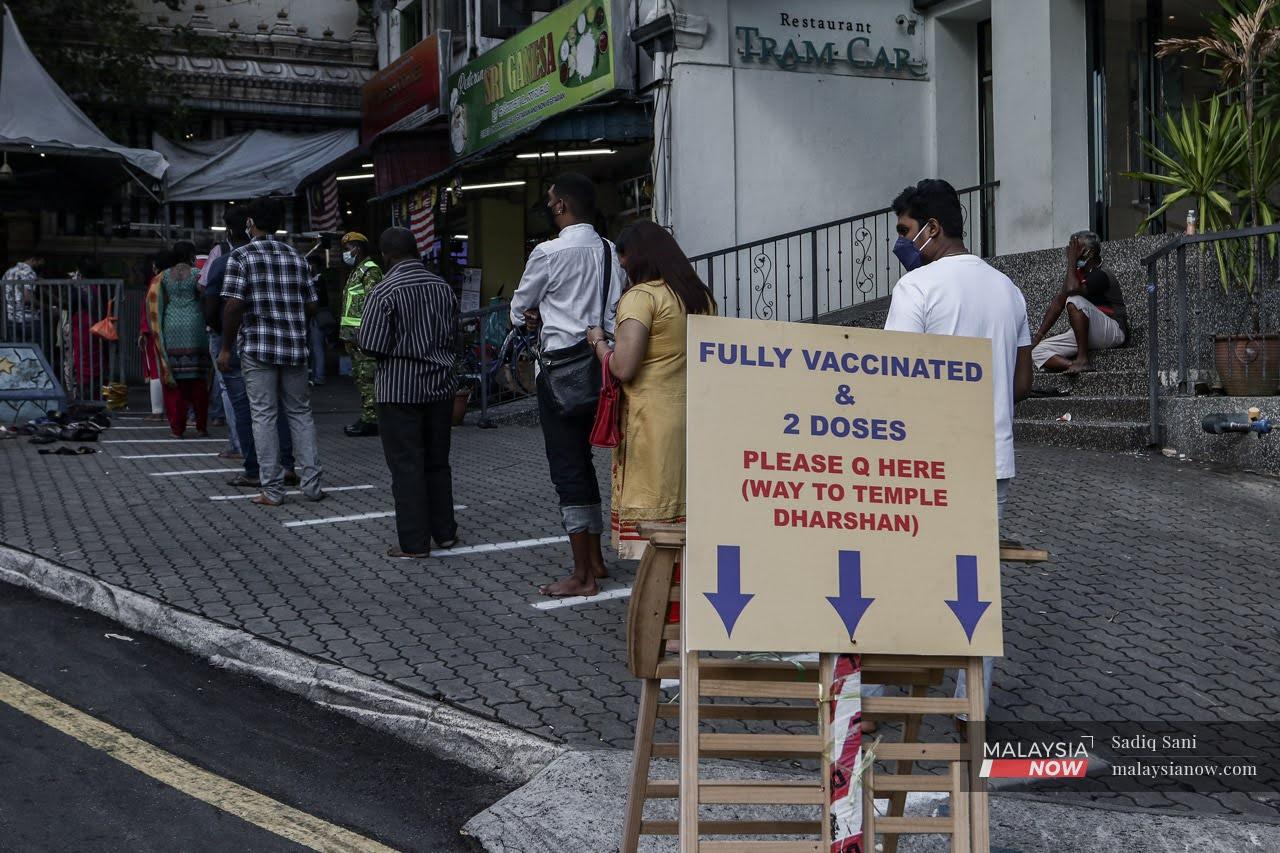 Individuals who have completed their vaccination queue to enter a temple in Jalan Pudu, Kuala Lumpur.
