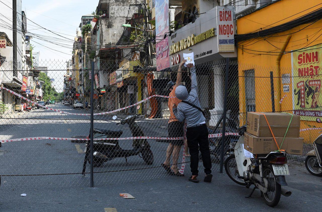 A man picks up groceries through a barrier in a quarantine area amid the Covid-19 outbreak as the population continues to battle a devastating fourth wave of the virus, in Hanoi, Vietnam, Sept 6. Photo: Reuters