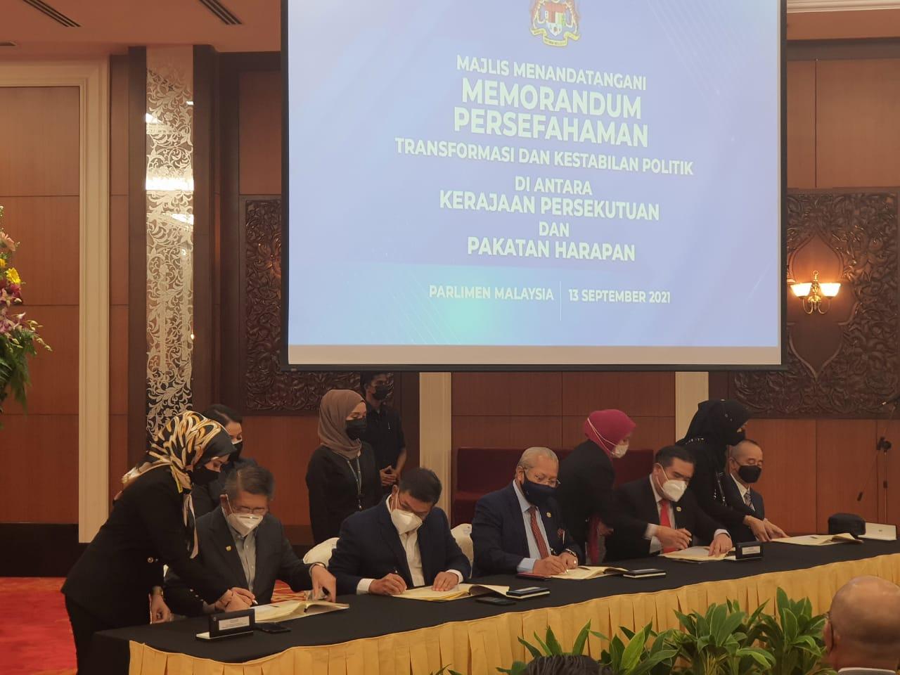 Representatives from the government and opposition sign a memorandum of understanding at Parliament in Kuala Lumpur today.
