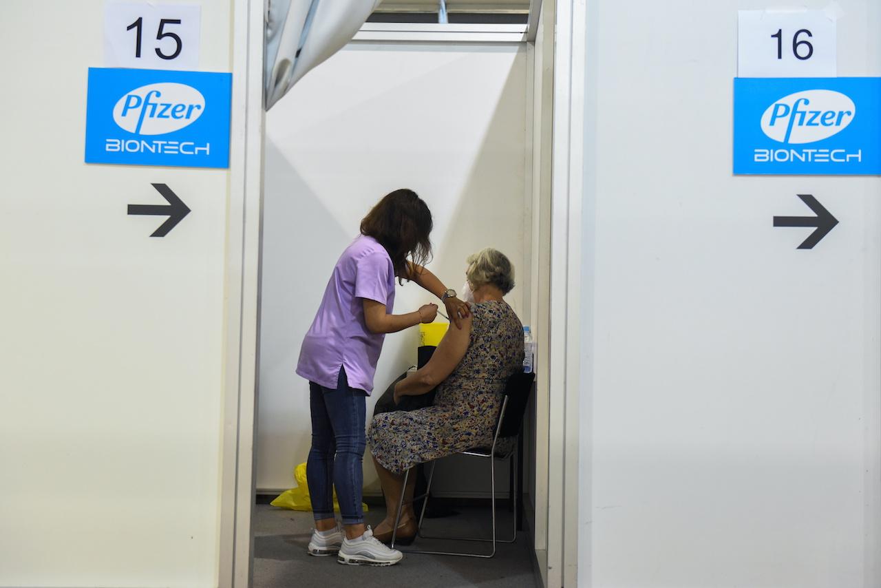 A healthcare worker administers a third dose of Pfizer's Covid-19 vaccine to a woman at the Belgrade Fair vaccination centre in Belgrade, Serbia, Aug 25. Photo: Reuters