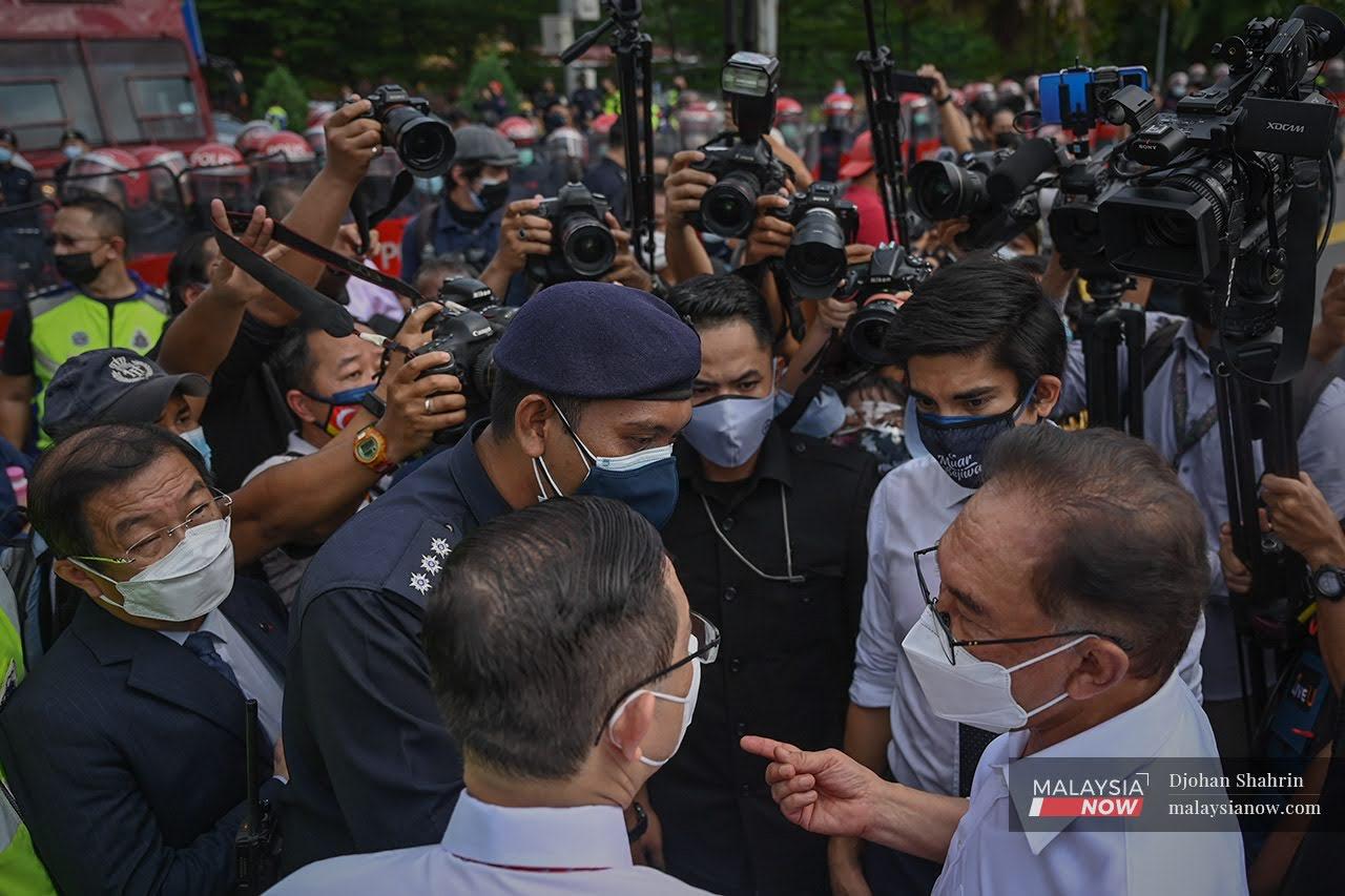 Opposition leader Anwar Ibrahim with Bagan MP Lim Guan Eng and Muar MP Syed Saddiq Syed Abdul Rahman at the police barricade blocking MPs from entering Parliament on Aug 2.