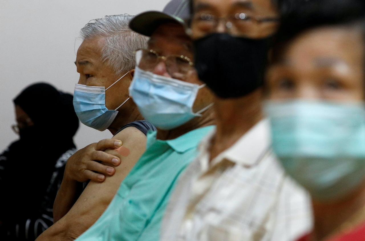 People wait at an observation area after their Covid-19 vaccination at a centre in Singapore, March 8. Photo: Reuters