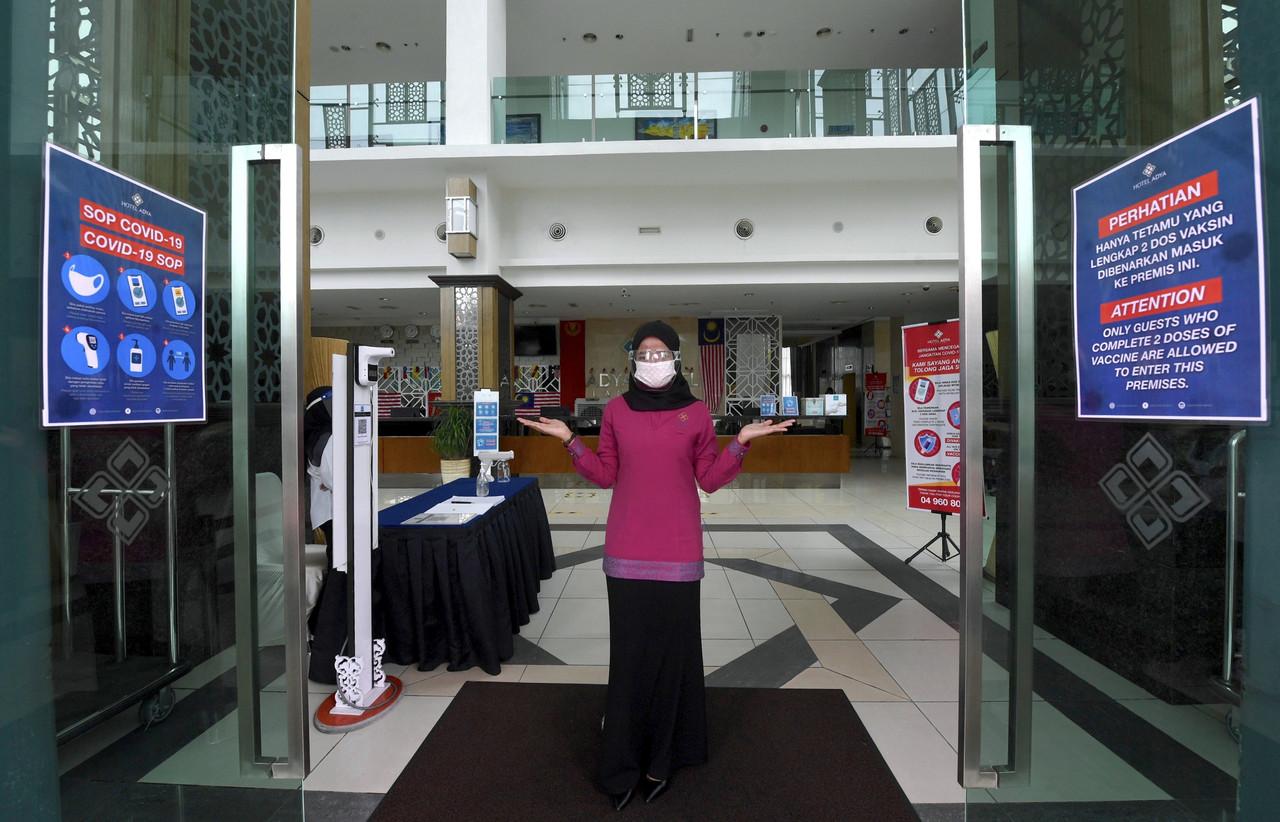 A staff member at a hotel in Langkawi stands ready to receive guests ahead of the domestic travel bubble to the island which will open tomorrow. Photo: Bernama