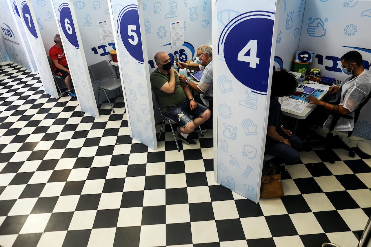Israelis receive their third shot of Covid-19 vaccine as the country launches booster shots for over 30-year-olds, in Rishon Lezion, Israel, Aug 24. Photo: Reuters