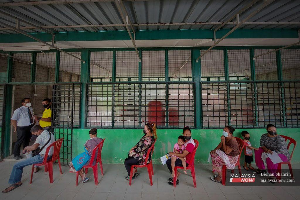 Orang Asli Temuan menunggu giliran untuk menerima suntikan vaksin Covid-19 di Hulu Langat, Selangor.