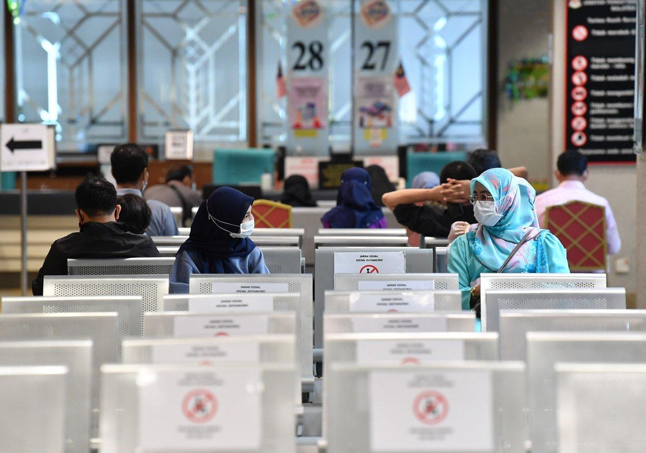 Women wait for their turn to be served at the National Registration Department in Putrajaya, July 1. Without citizenship, children born overseas to Malaysian mothers are unable to attend public schools or receive government assistance. Photo: Bernama