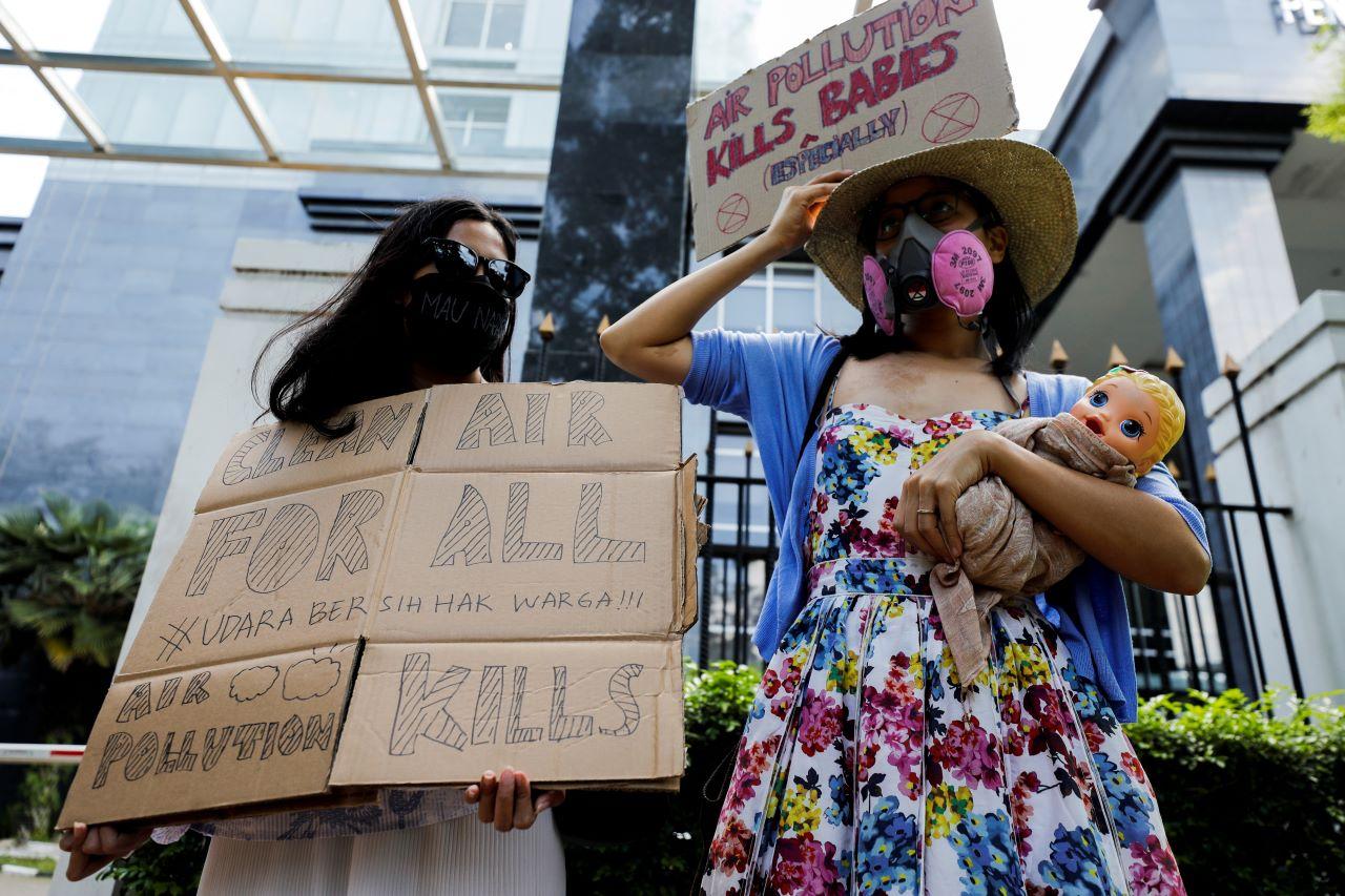 Environmental activists wearing protective masks hold placards outside the Central Jakarta Court following the hearing of a citizen lawsuit, done in an attempt to sue the government into taking action on the city's chronic levels of air pollution, in Jakarta, Indonesia, Sept 16. Photo: Reuters