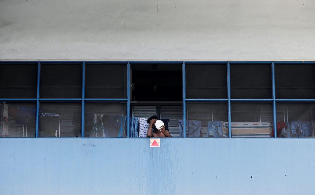 A migrant worker living in a factory-converted dormitory looks into a mirror after receiving a stay-home notice during the Covid-19 outbreak in Singapore, April 22, 2020. Photo: Reuters