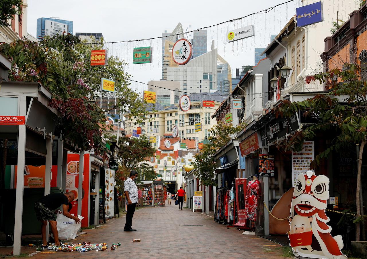 A man recycles aluminium cans in the largely empty Chinatown tourist district in Singapore, Aug 30. Photo: Reuters