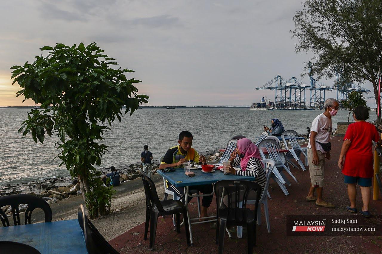 Customers who have completed their vaccination dine in at a waterfront restaurant near Tanjung Harapan in Klang.