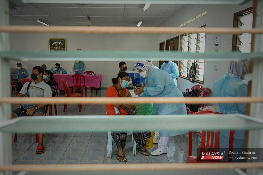 Health workers administer shots of Pfizer vaccine to Orang Asli recipients in Sungai Congkak, Hulu Langat.