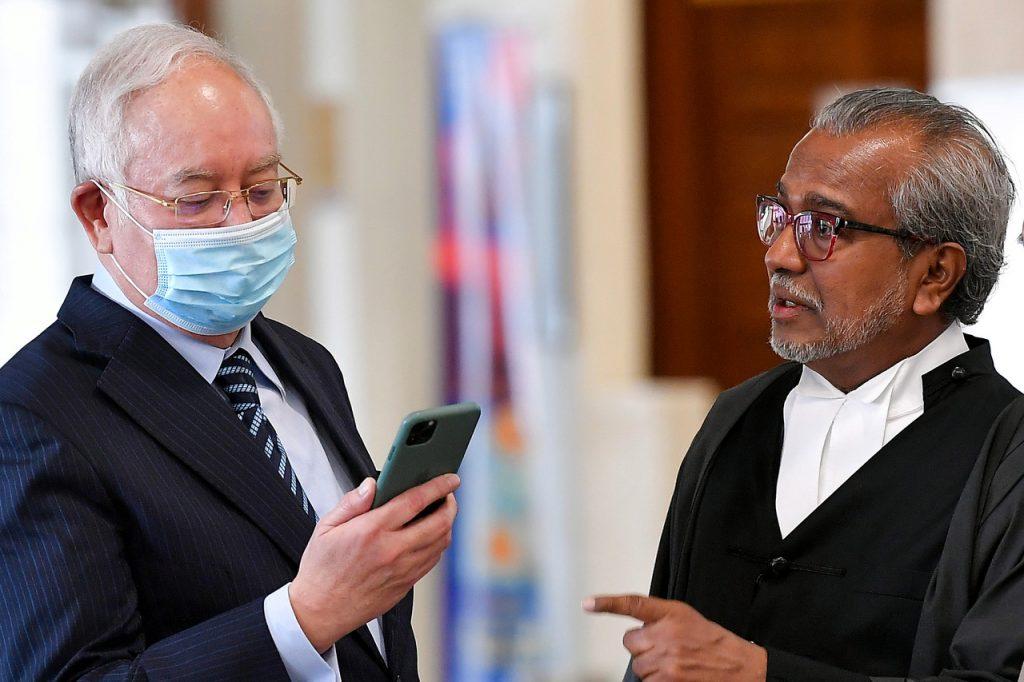 Bekas perdana menteri Najib Razak berbincang bersama peguamnya, Muhammad Shafee Abdullah ketika mahkamah berehat sebentar pada perbicaraan kes yang dihadapinya berhubung dana 1Malaysia Development Berhad (1MDB) di Mahkamah Tinggi Januari lalu. Gambar: Bernama