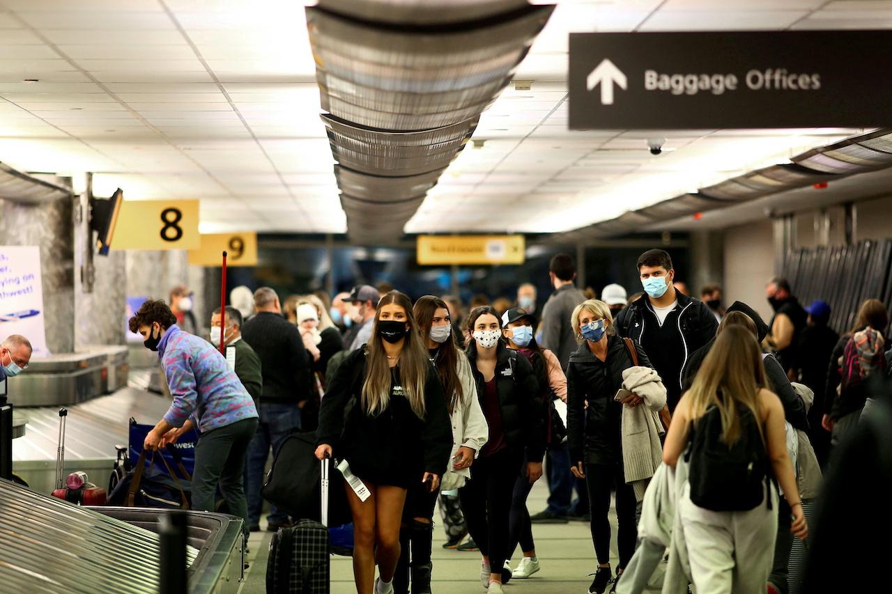 Travellers wearing protective face masks to prevent the spread of Covid-19 reclaim their luggage at the airport in Denver, Colorado, Nov 24, 2020. Photo: Reuters