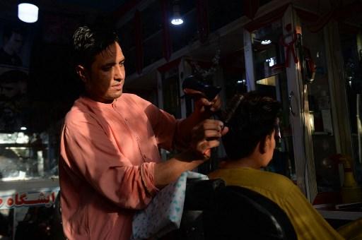 In this picture taken on Sept 19, a barber attends to his customer in Herat. Photo: Reuters