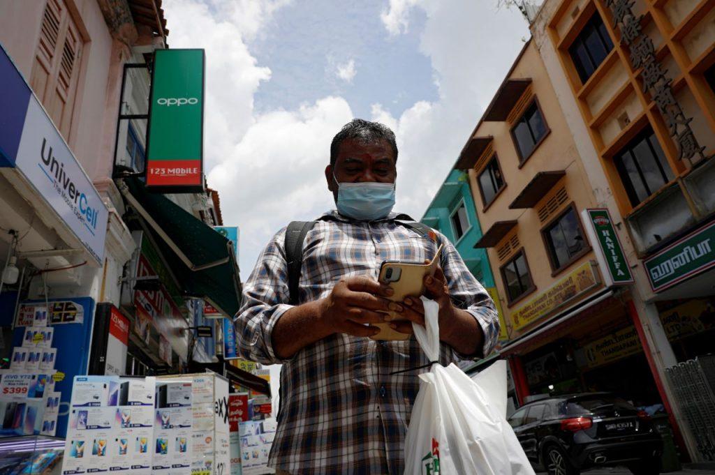 Seorang pekerja dari India membeli barang keperluan di Little India, Singapura dengan memakai pelitup muka bagi mengelak daripada jangkitan Covid-19. Gambar: Reuters