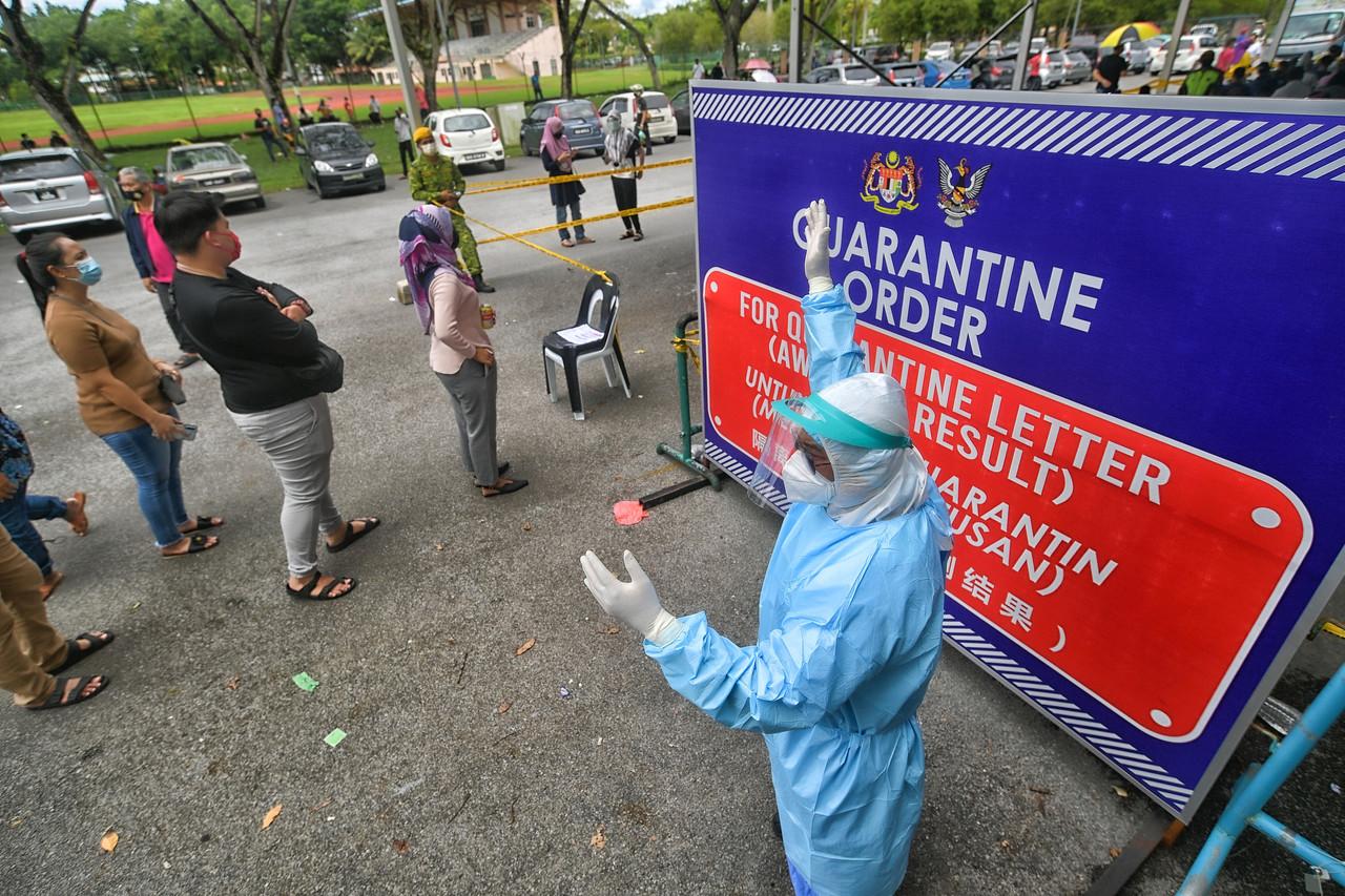 A health worker instructs members of the public on obtaining close contact quarantine forms near the South Kuching City Council community hall in this Aug 25 file photo. Photo: Bernama