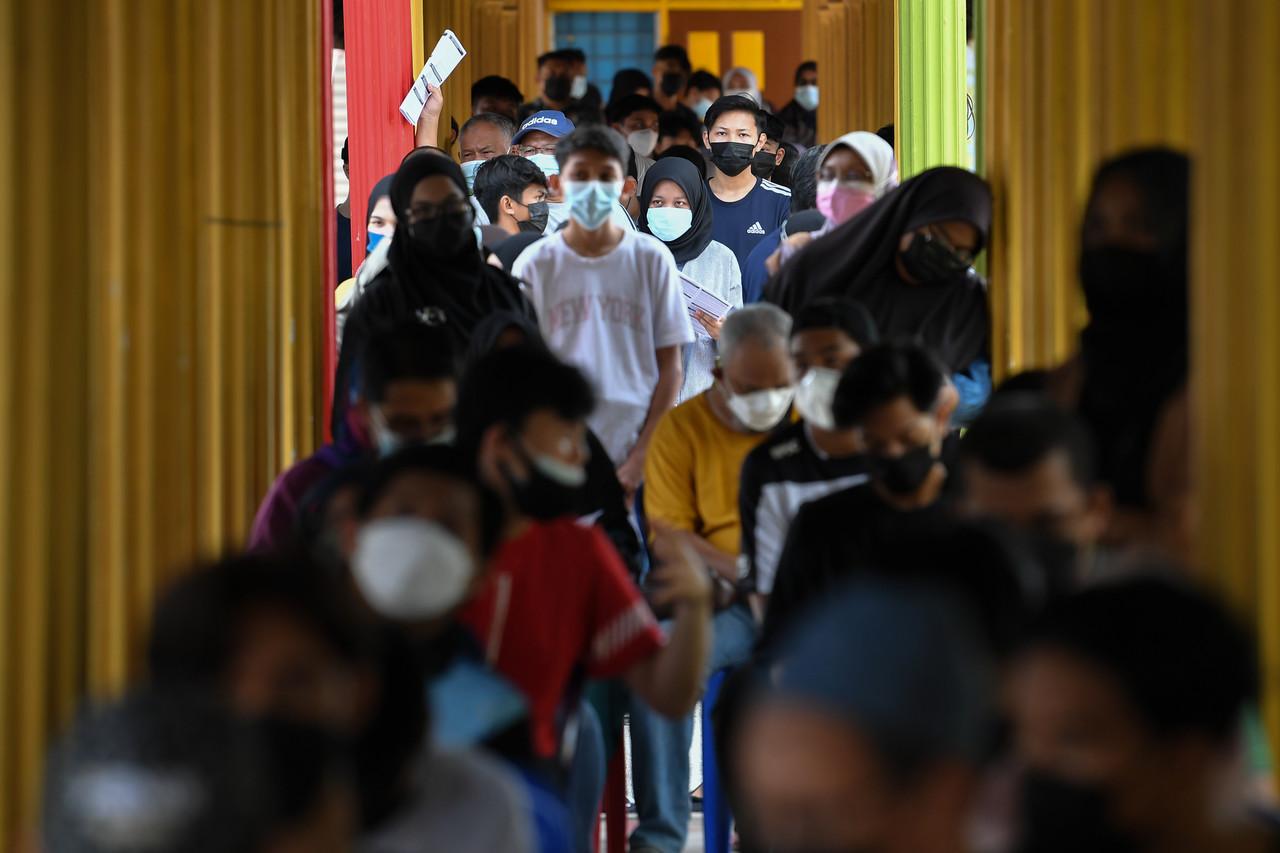 Students accompanied by their parents wait to receive a dose of Covid-19 vaccine at SMK Sultan Sulaiman in Kuala Terengganu. Photo: Bernama