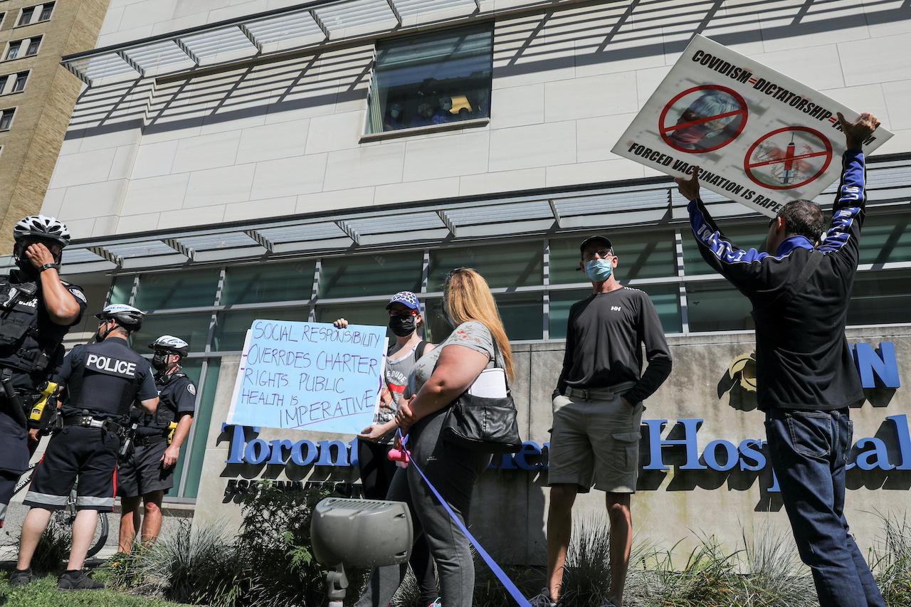 Protesters hold signs during an anti-vaccine mandate protest outside Toronto General Hospital in Toronto, Ontario, Sept 13. Anti-vaccine protests across Canada had ramped up in the run-up to this week's federal election. Photo: Reuters