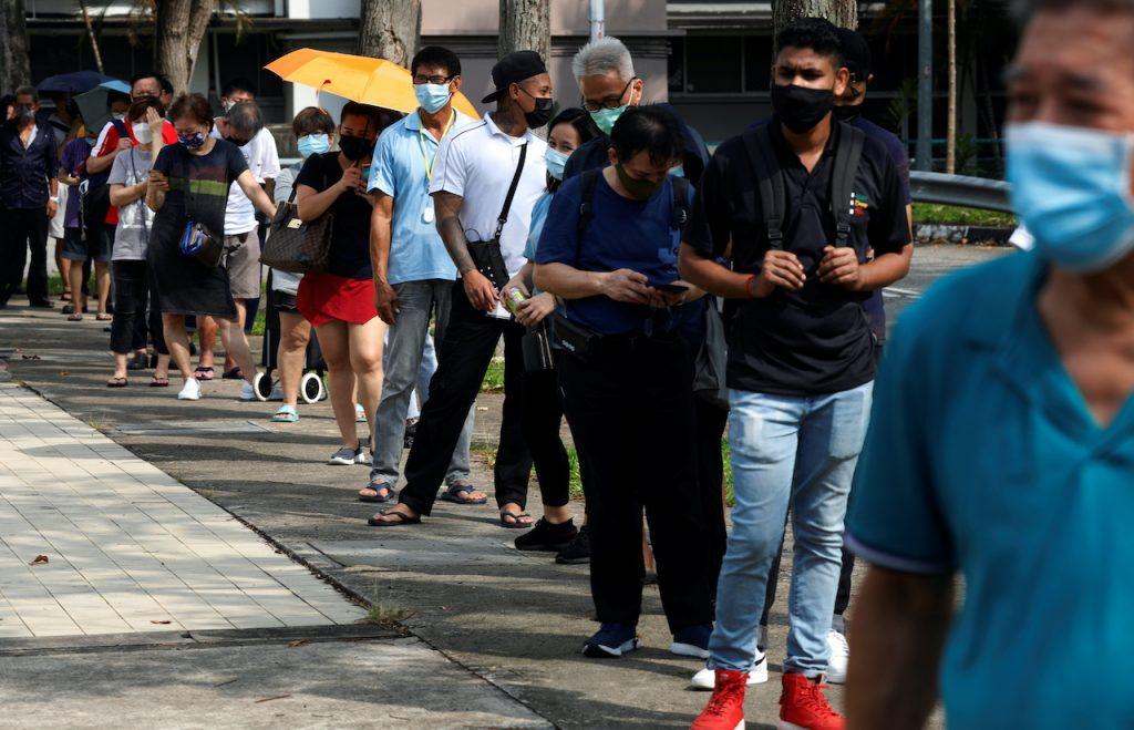 Orang ramai beratur di pusat ujian saringan segera Covid-19 di Singapura pada 21 September. Gambar: Reuters