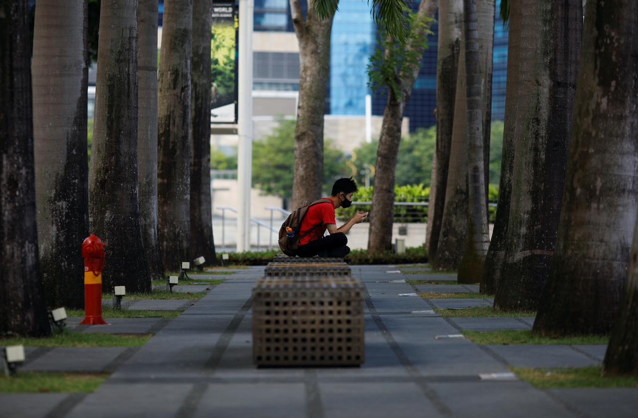 A man wearing a face mask sits outside a mall in Singapore, Sept 22. Photo: Reuters