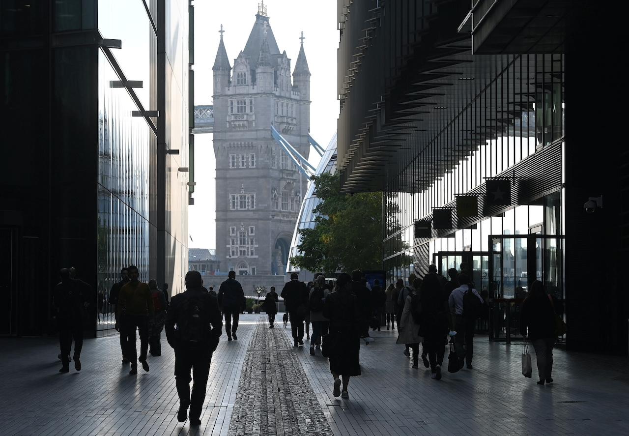 Commuters walk towards Tower Bridge during the morning rush hour, amid a relaxation of lockdown restrictions in London, Sept 15. Photo: Reuters
